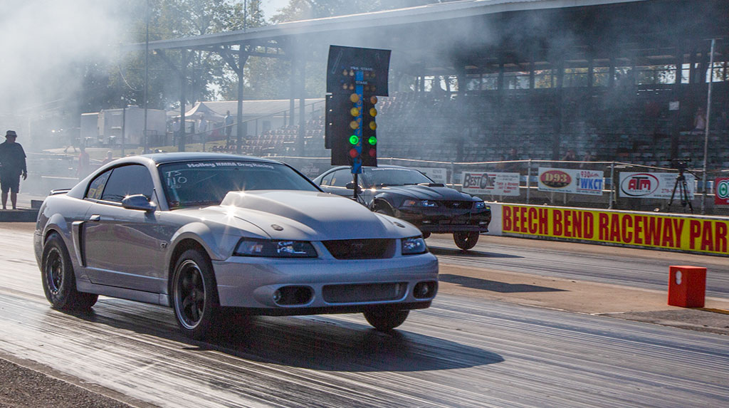 The stage was set at the Whipple Superchargers 2023 NMRA World Finals for the TREMEC Stick Shift Shootout drag racing finale of the season. The build up for the third shootout of the season had everyone revving with anticipation to see who would show up, if any grudges from the previous 2023 shootouts would carry over to the season showdown and, when the tire smoke cleared, would we see a repeat or first-time winner?
The TREMEC Stick Shift Shootout takes the quickest eight H-pattern manual transmission cars from the NMRA True Street class and pits them against each other in a staggered-start elimination format that gives all eight qualifiers a shot at winning the title and taking home the top prize. Normally that prize is a McLeod Racing RXT clutch kit for the winner and a $500 McCleod gift certificate for the runner up, but for the last shootout of 2023 both TREMEC and McLeod Racing decided to sweeten the pot by adding $1,000 each for the winner if the car is equipped with a TREMEC transmission and/or a McLeod Racing clutch. That put an extra $2,000 up for grabs to the winner!
It was one of many firsts we saw at this event. In addition to such a big cash purse, it was also the quickest ever TREMEC Stick Shift Shootout field with an average qualifying E/T of 9.558 seconds. Besides one entry from West Virginia, it was exclusively a battle of North versus South racers with three qualifiers from Florida and four from Ohio. 
Multiple racers added their own variables to the competition. Ohio’s Dan Watts had just fired up a new engine in his car for the first time the night before showing up on Friday of the event. He was also chasing a fuel pressure gremlin. Mike Niehaus from Ohio detected a possible clutch or clutch-cable issue during test-n-tune on Friday. Florida’s Kyle Miller encountered a heat issue affecting his clutch during the True Street cruise that had him fighting to get an average E/T good enough to qualify. 
All eight racers who made the final TREMEC Stick Shift Shootout of 2023 didn’t hold anything back during their True Street runs. This put on quite a show and gave us a tight field where the staggered start wouldn’t be as large a factor as in our previous two shootouts this year. It also gave us one more first: this was the quickest field ever for TREMEC Stick Shift Shoout, with qualifying cars running between 8.717 and 10.125 second E/Ts. 
Who would come out on top? Would there be any huge upsets? We didn’t know, but it was certain this was going to be the most exciting TREMEC Stick Shift Shootout from start to finish ever! Follow the action in the photos and captions for run-by-run details.
