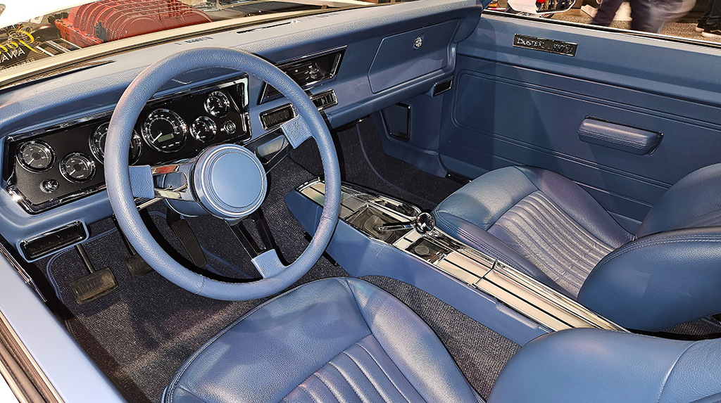 Parked in the Racing Junk booth was this killer 1971 Plymouth Duster built by BBT Fabrications. It features a custom-built full frame, with a supercharged Hellcat Hemi V8 crate engine and Bowler Performance TREMEC Magnum 6-speed transmission. We love the blue leather interior paired with the white exterior. 