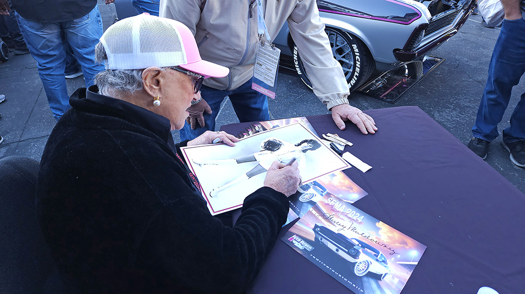 After the unveiling of the Red River Customs Cha-Cha Nova, Shirley Muldowney signed autographs for fans. Besides her own promotional photos, fans brought a variety of things including race helmets signed by other famous drag racers for Shirley to add her signature. 