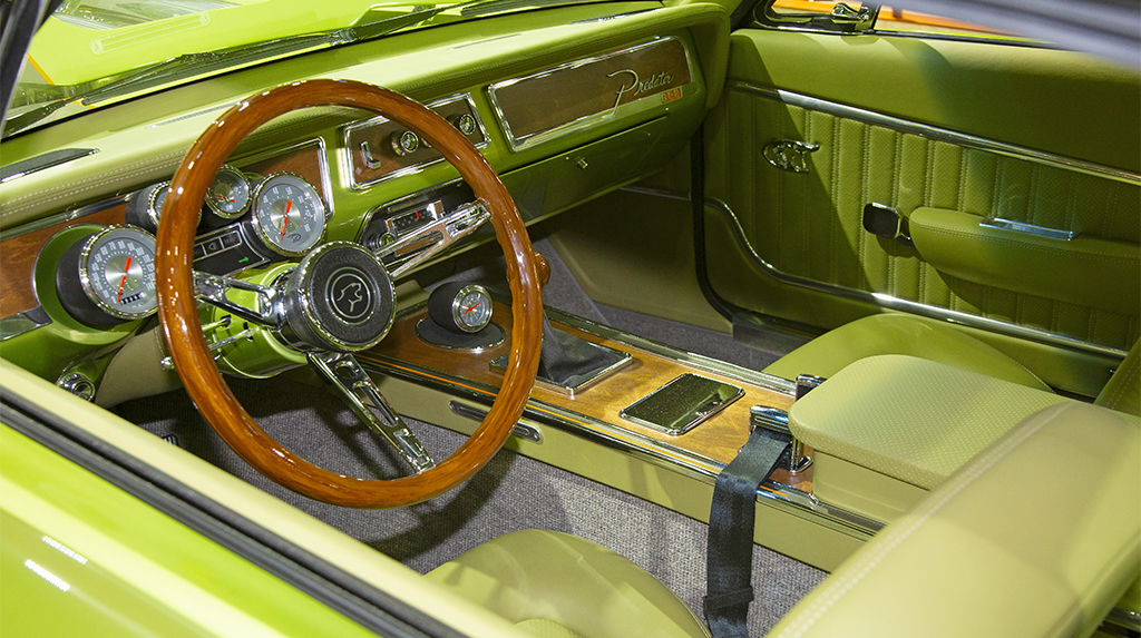 The Mercury Predator’s interior stuck with the “what-if” factory built theme down to small details. It mimics original wood accents of the Cougar, while other interior accents were made from machined aluminum and 3D printed materials. The modern gauges were built and installed ralley pack style. Lee Baxters Hot Rod Interiors helped with getting the factory looking interior just right to go with the JF Kustoms parts. The shifter for the Predator’s TREMEC TKX five-speed has a simulated wood grain knob matching the interiors wood accents. 