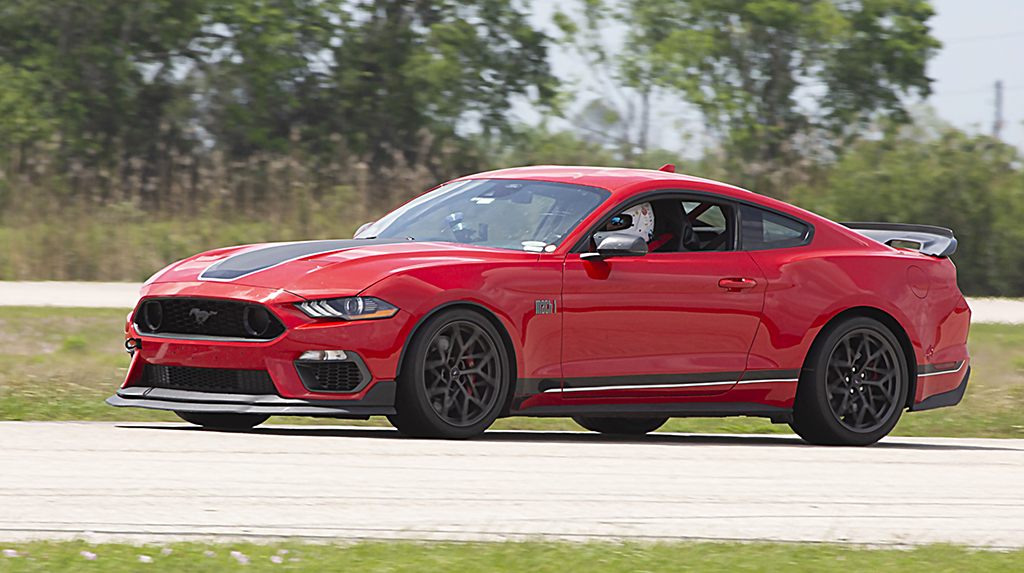 A red 2022 Ford Mustang Mach 1 races on the road course at the 2026 Mustang Week Texas track day