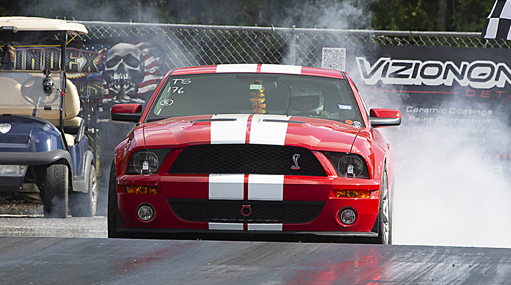 A Ford S197 Shelby Mustang GT500 does a burnout at a dragstrip prior to making an eighth-mile timed run