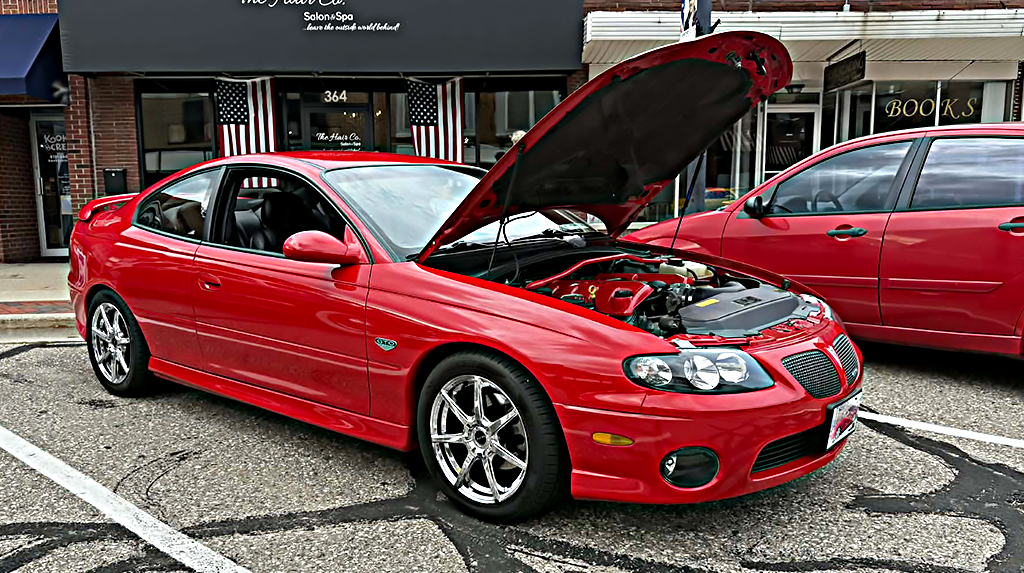 2005 Pontiac GTO with the hood open while parked on main street in Michigan for a cruise night event