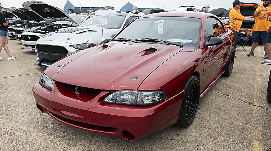 Dark red 1995 Ford Mustang Cobra parked in the show field at Mustang Week Texas 2026