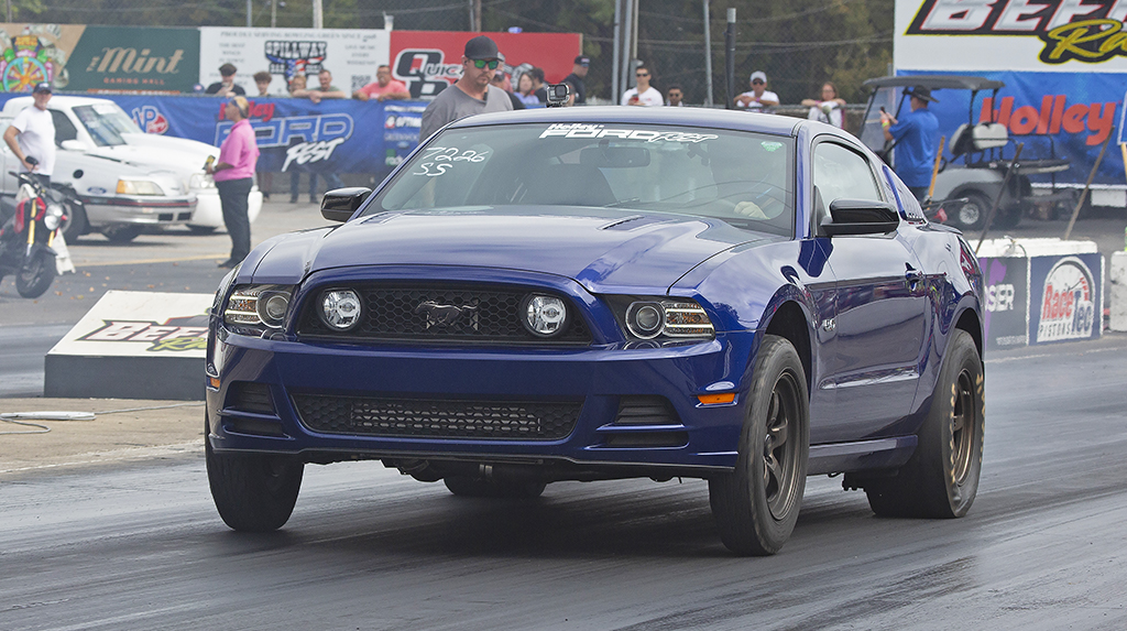 A blue 2014 Ford Mustang drag races at Beech Bend Raceway during the 2026 Holley Ford Fest