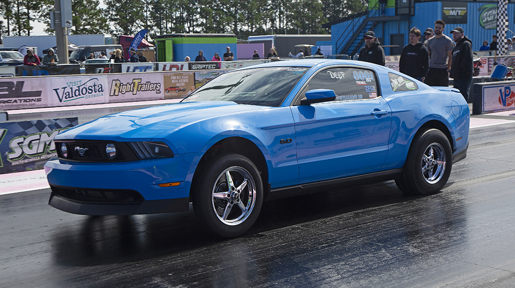 A 2012 Ford Mustang GT launches hard from the starting line while drag racing