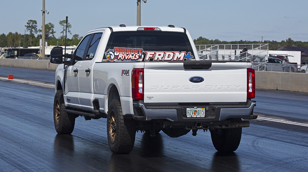A Ford F-250 goes down a dragstrip at high speed while drag racing